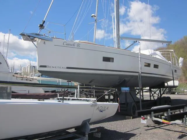 Cameli Yacht Photos Pics 2020 Beneteau Oceanis 55.1 sailboat on trailer, docked at marina under blue sky.