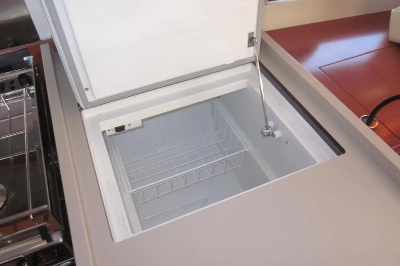 Cameli Yacht Photos Pics Built-in freezer on 2020 Beneteau Oceanis 55.1 yacht, open with wire basket inside.
