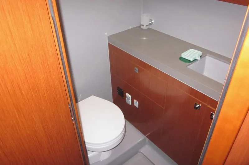 Cameli Yacht Photos Pics Bathroom interior of 2020 Beneteau Oceanis 55.1 yacht, featuring modern fixtures and wooden cabinetry.