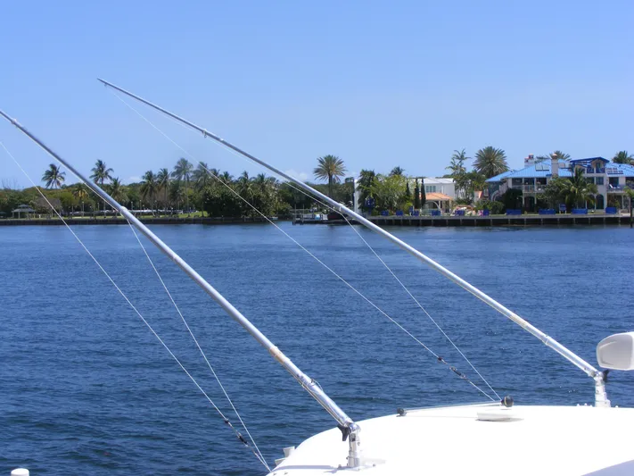  Yacht Photos Pics 2020 Cobia 350 Center Console boat with fishing rods on a calm waterfront.