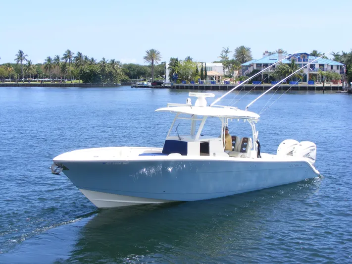  Yacht Photos Pics 2020 Cobia 350 Center Console boat cruising on a sunny day near waterfront homes.