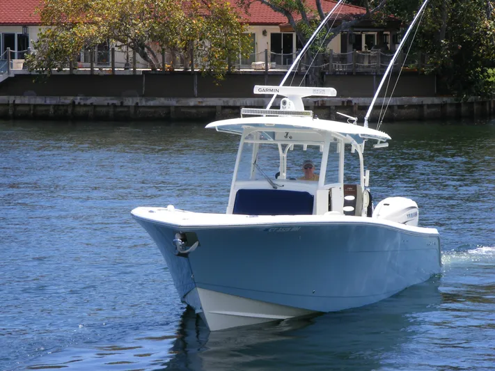 Yacht Photos Pics 2020 Cobia 350 Center Console boat cruising on a sunny day near waterfront homes.
