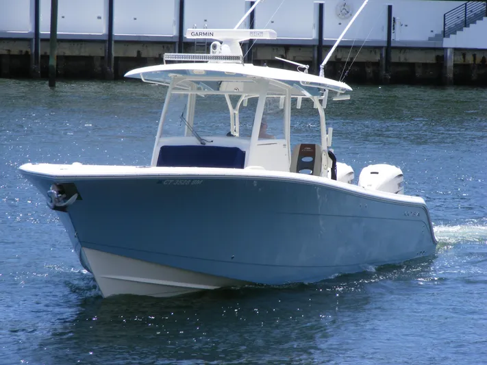  Yacht Photos Pics 2020 Cobia 350 Center Console boat cruising on water near a dock.