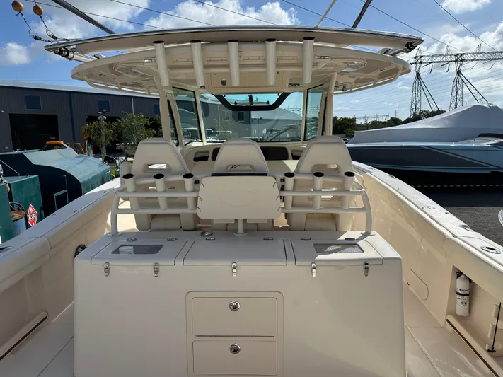  Yacht Photos Pics 2023 Grady-White Canyon 376 boat interior with seating and storage, docked under clear skies.