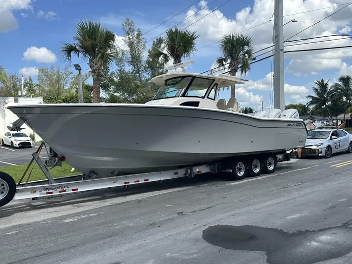  Yacht Photos Pics 2023 Grady-White Canyon 376 boat on trailer, parked on street with palm trees.
