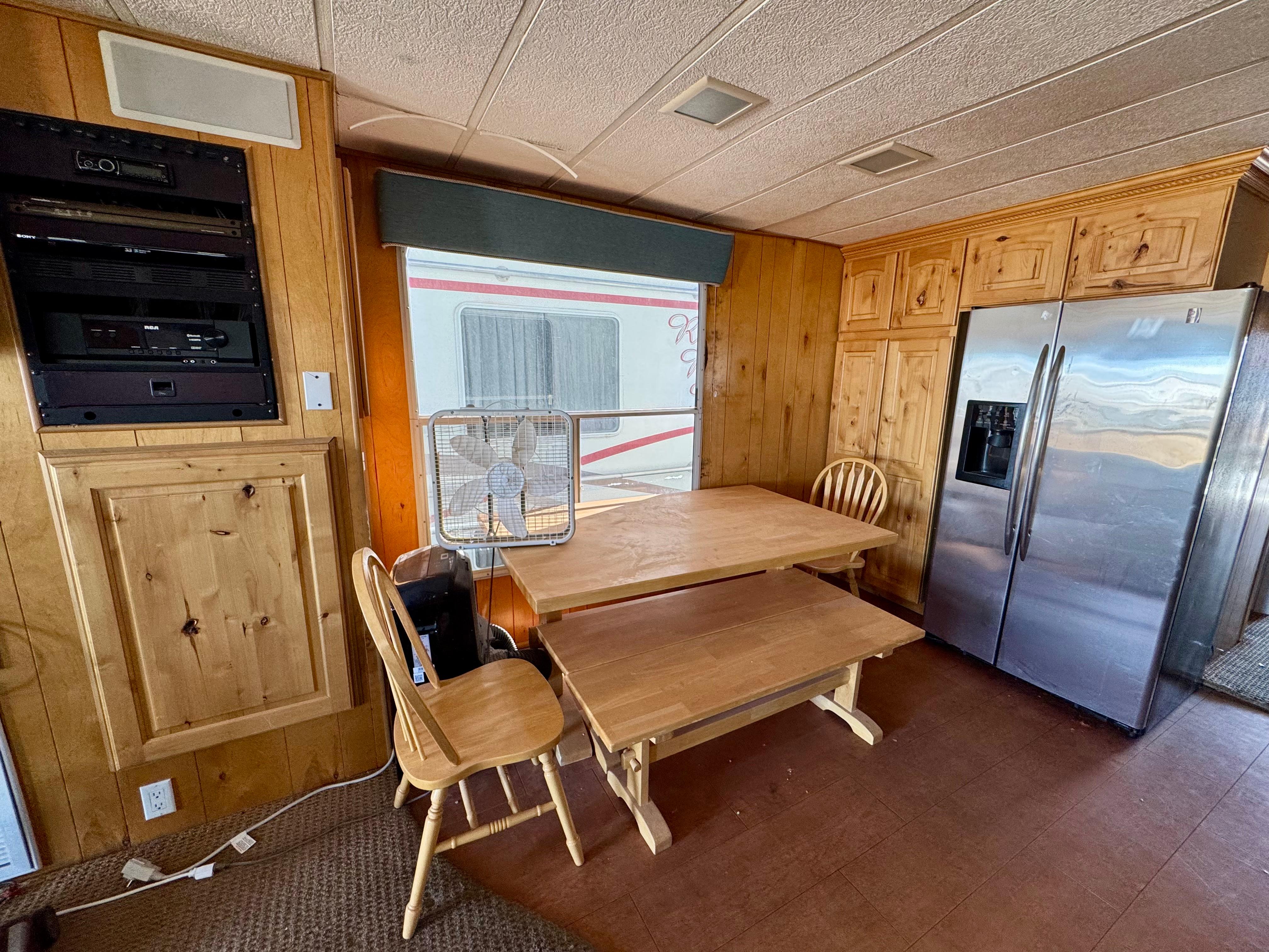 Cozy kitchen with wooden cabinets, dining table, and stainless steel refrigerator in a Lakeview 1993 model.