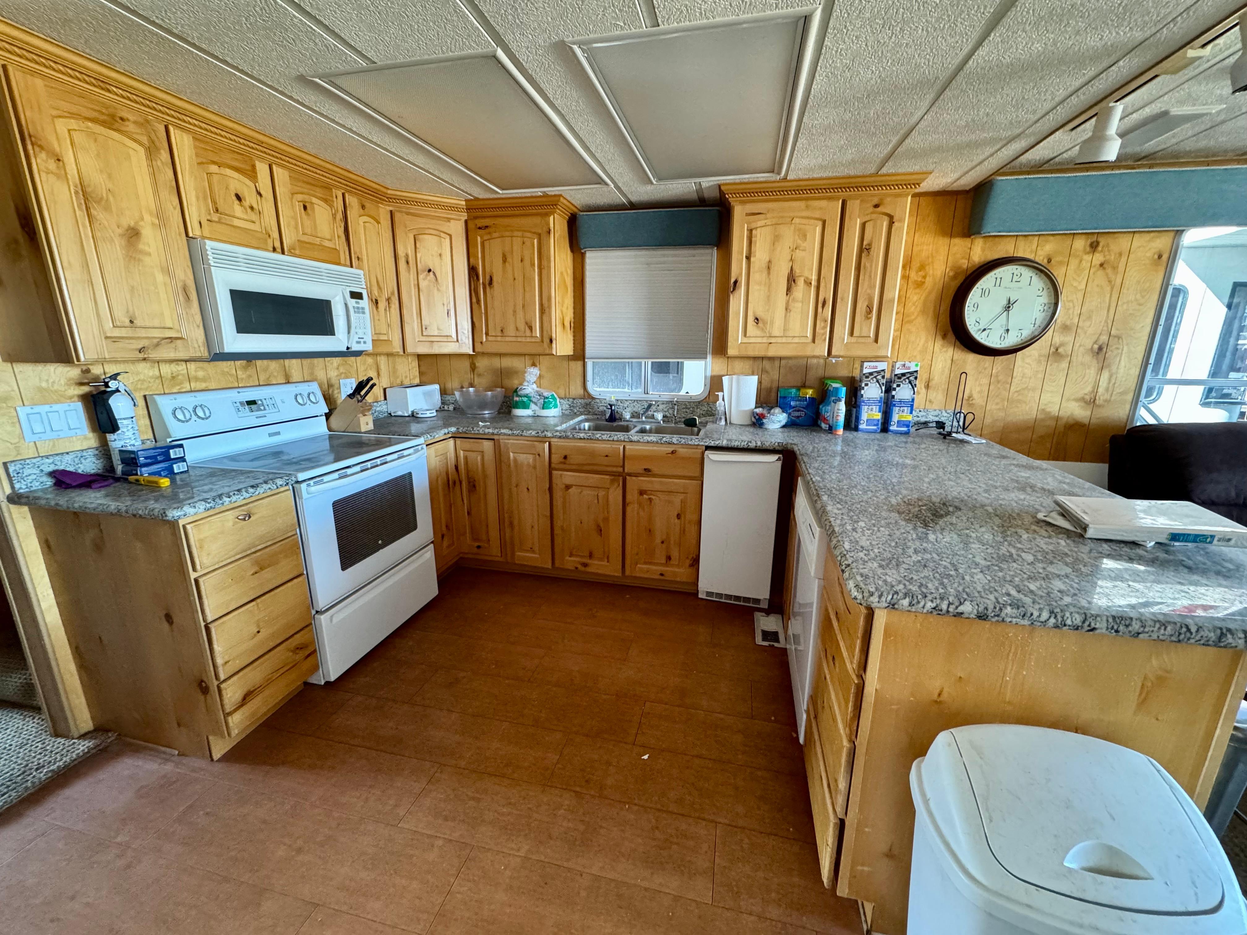 Spacious kitchen with wooden cabinets, granite countertops, and modern appliances in a Lakeview model.