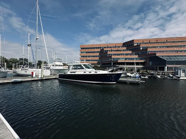Someday Yacht Photos Pics 2012 Back Cove 34 yacht docked at marina with modern building backdrop.