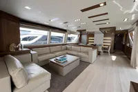 Luxurious yacht interior with modern design, featuring beige leather seating and large windows. Custom Line 100, 2015.