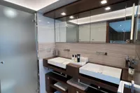 Modern yacht bathroom with dual sinks, sleek mirrors, and ambient lighting, Custom Line 100, 2015.