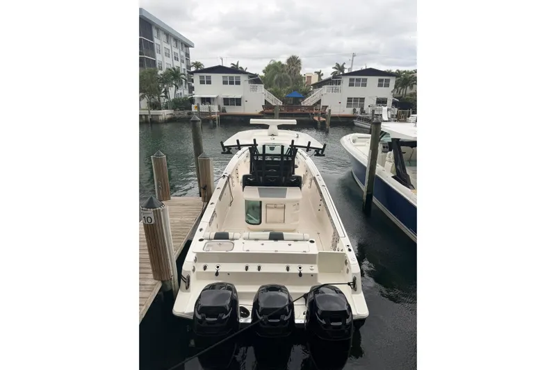  Yacht Photos Pics 2019 Wellcraft 352 Fisherman boat docked in a marina with triple outboard engines.
