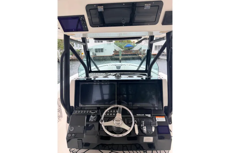 Yacht Photos Pics 2019 Wellcraft 352 Fisherman boat dashboard with steering wheel and navigation screens.