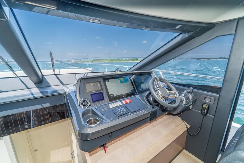  Yacht Photos Pics Modern helm of 2023 Absolute 62 Fly yacht with navigation screens and steering wheel.