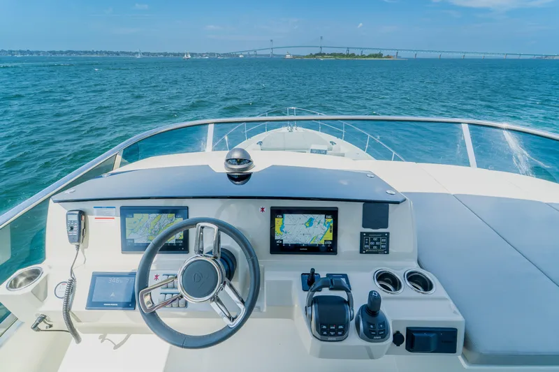  Yacht Photos Pics 2023 Absolute 62 Fly yacht helm with navigation screens, steering wheel, and ocean view.