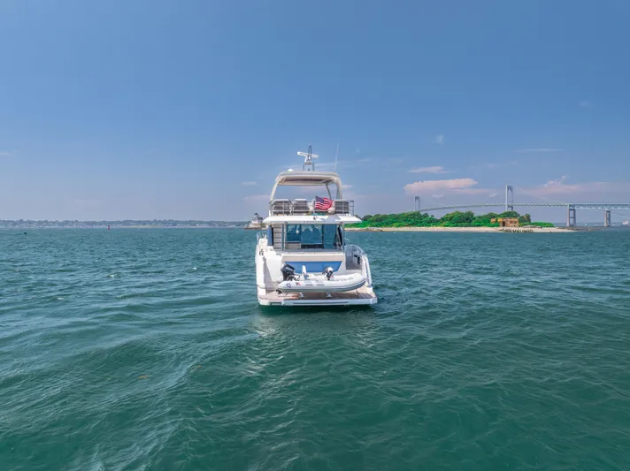  Yacht Photos Pics 2023 Absolute 62 Fly yacht on open water near a bridge and island.