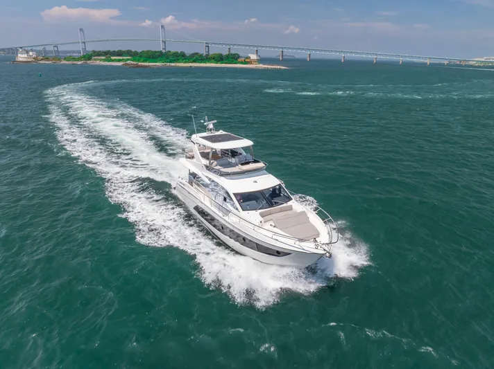  Yacht Photos Pics 2023 Absolute 62 Fly yacht cruising near a bridge on a sunny day.