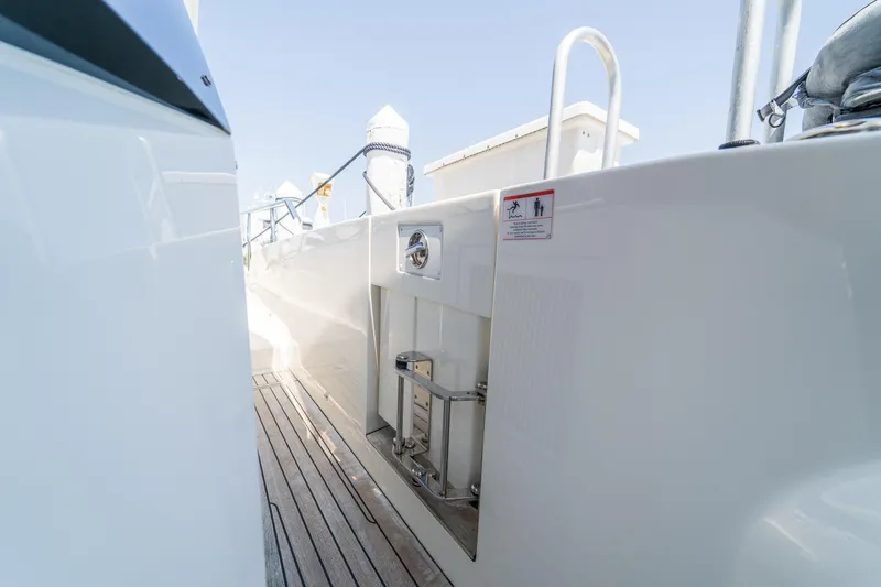  Yacht Photos Pics Side view of 2023 Absolute 62 Fly yacht with sleek white exterior and wooden deck.