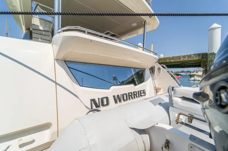  Yacht Photos Pics 2023 Absolute 62 Fly yacht docked, featuring "No Worries" text on the stern.