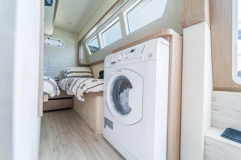  Yacht Photos Pics Interior of 2023 Absolute 62 Fly yacht with washing machine and cozy bedding.