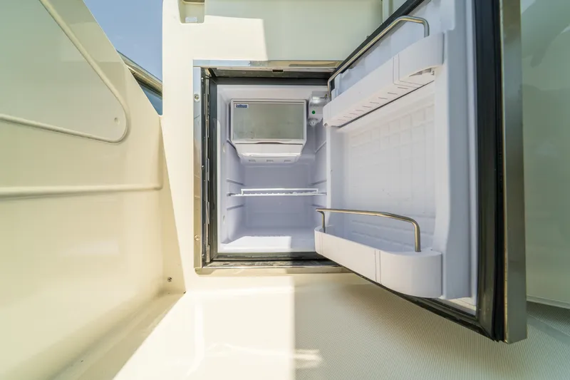  Yacht Photos Pics Open refrigerator on 2023 Absolute 62 Fly yacht, showcasing interior storage space.