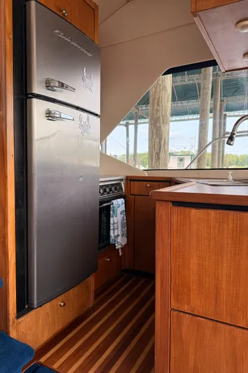  Yacht Photos Pics 2000 Bayliner 4087 Aft Cabin Motoryacht kitchen with wood cabinetry and stainless steel appliances.