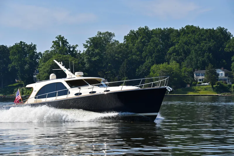 Mack Yacht Photos Pics 2020 Palm Beach Motor Yachts PB52 cruising on a serene lake with lush greenery.