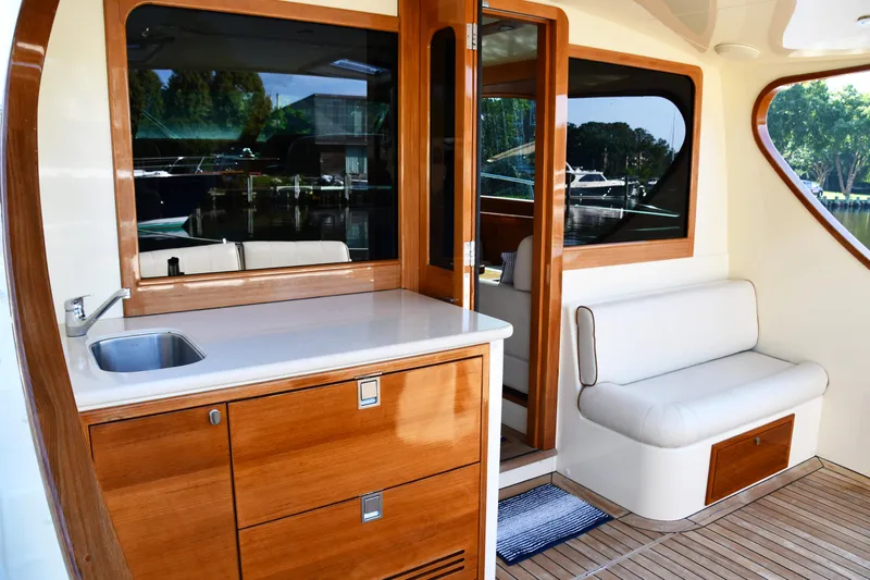 Mack Yacht Photos Pics 2020 Palm Beach Motor Yachts PB52 interior with wooden cabinetry and seating area.