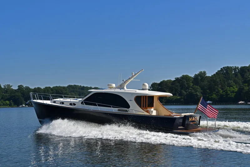 Mack Yacht Photos Pics 2020 Palm Beach Motor Yachts PB52 cruising on a serene lake under a clear blue sky.