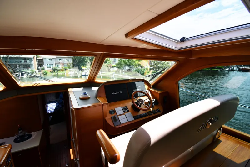 Mack Yacht Photos Pics Interior view of 2020 Palm Beach Motor Yachts PB52 helm with wooden accents and water view.