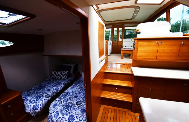 Mack Yacht Photos Pics Luxurious interior of 2020 Palm Beach Motor Yachts PB52 with elegant wood finishes and twin beds.