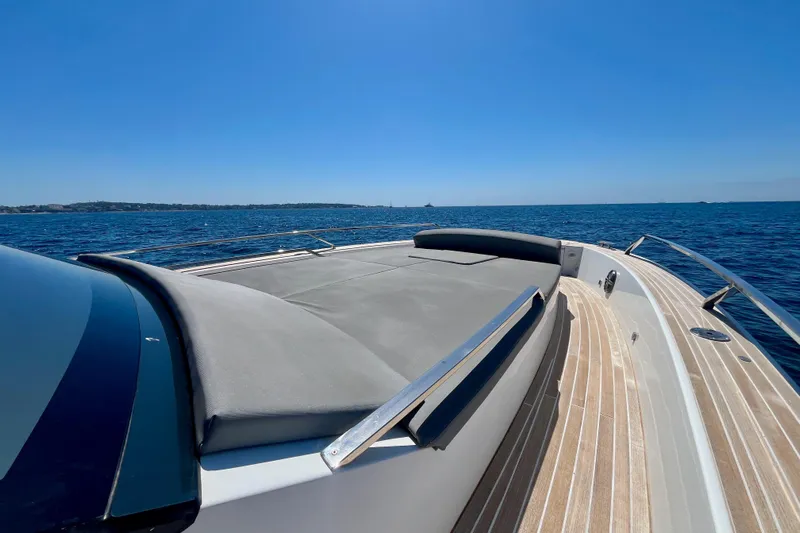 Blue Moon Yacht Photos Pics 2021 Fiart 43 yacht deck with sunbed, cruising on open sea under clear blue sky.