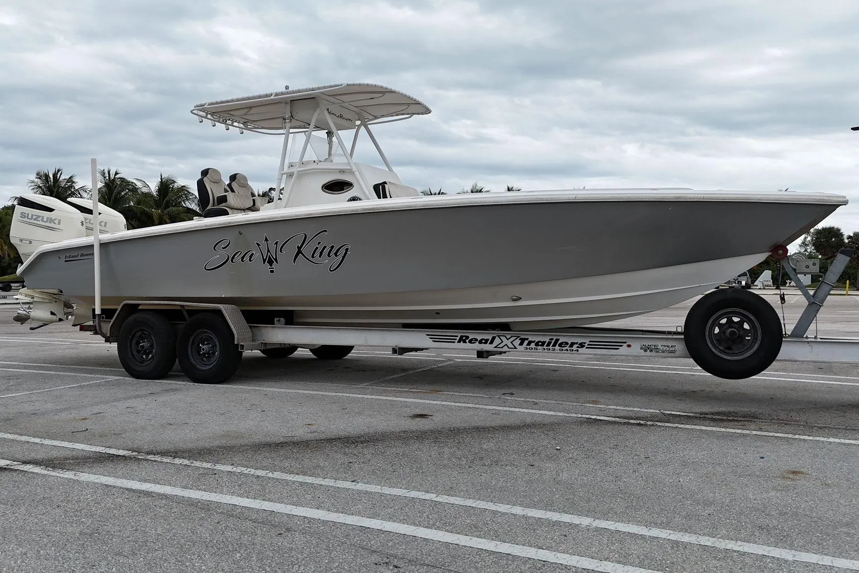 2002 Island Runner 31 boat on trailer, labeled "Sea King," parked in a lot.