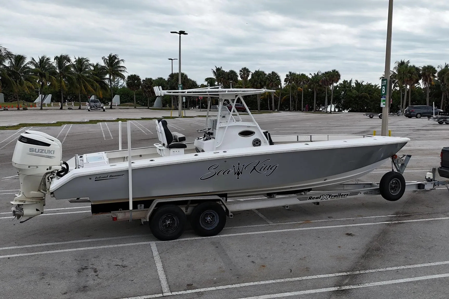 2002 Island Runner 31 boat on trailer in parking lot with palm trees.