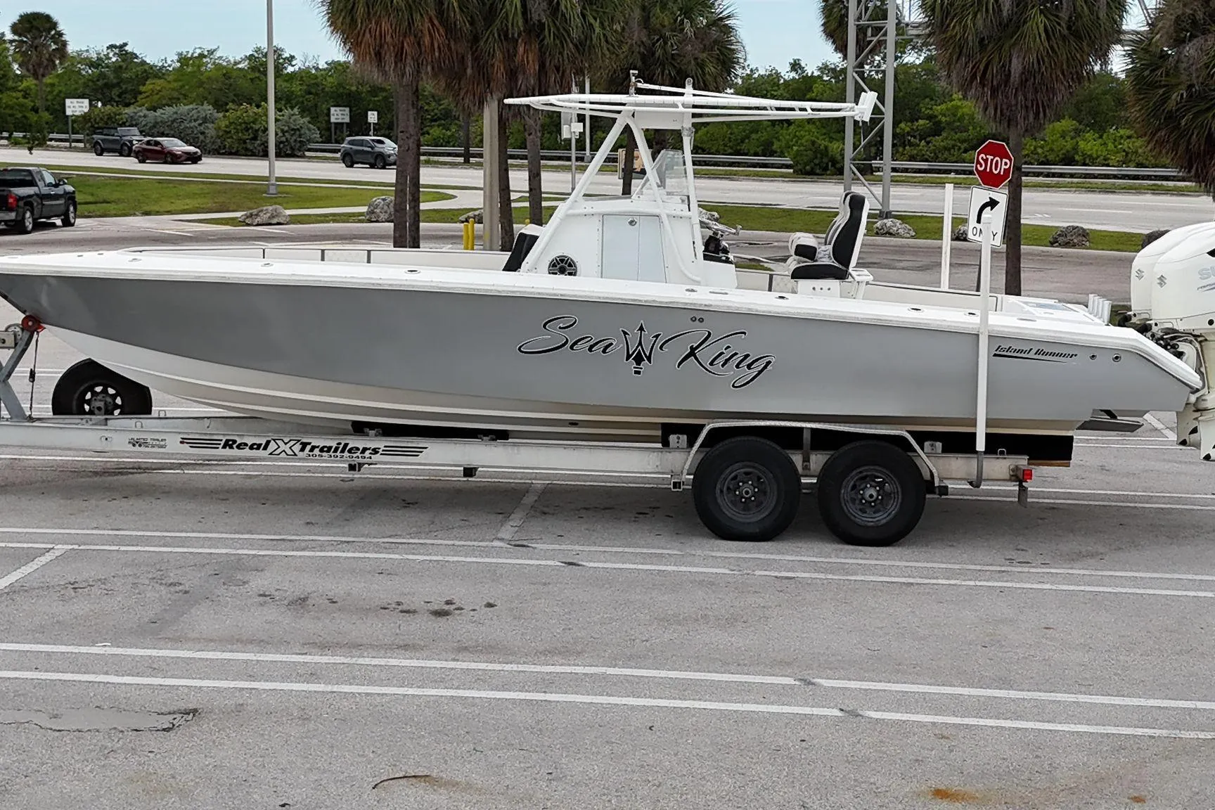 2002 Island Runner 31 boat on trailer, labeled "Sea King," parked near palm trees.