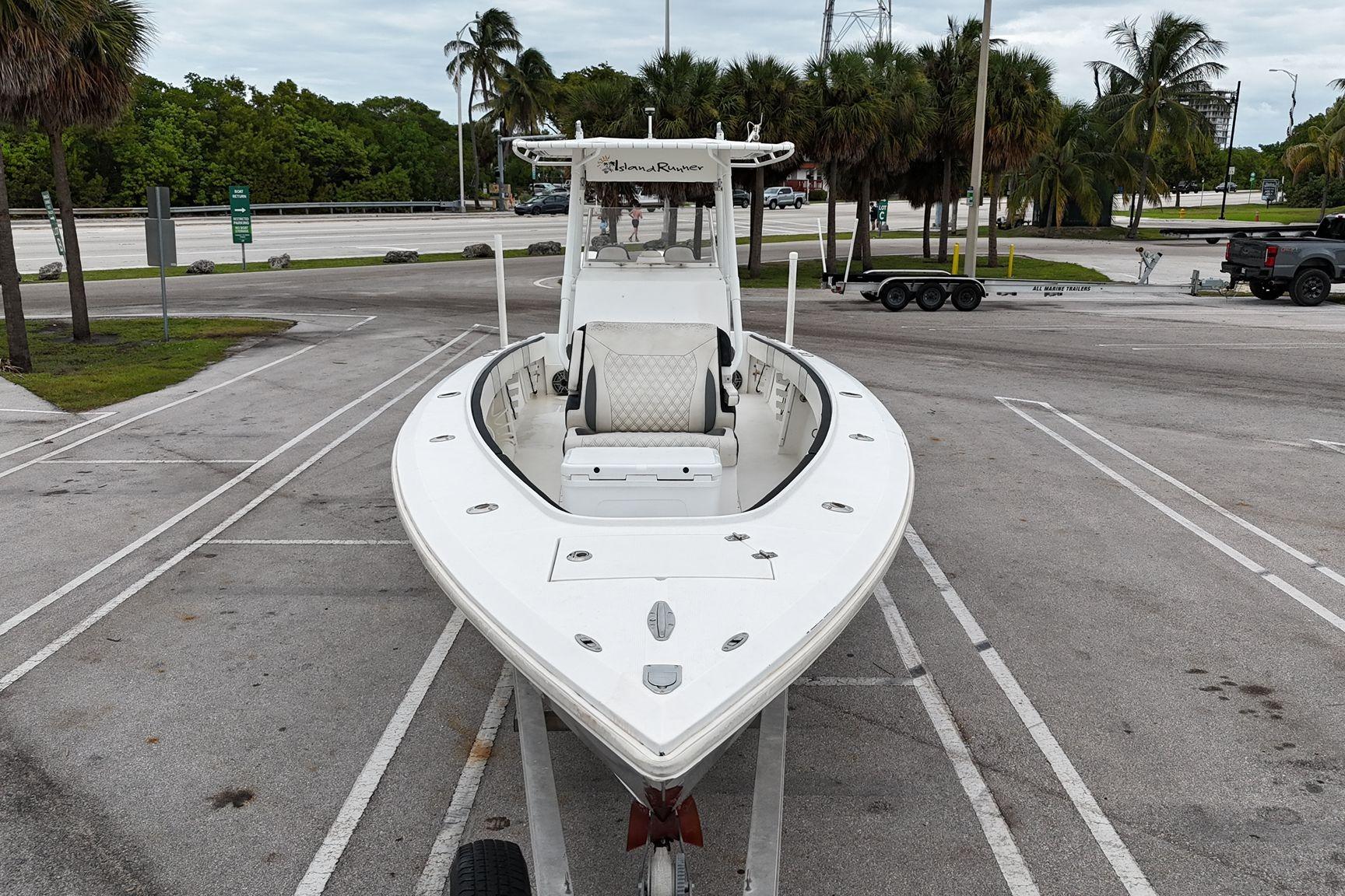 2002 Island Runner 31 boat on trailer in parking lot with palm trees.