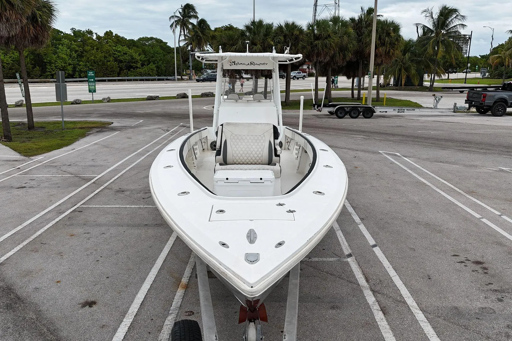 2002 Island Runner 31 boat on trailer in parking lot with palm trees.
