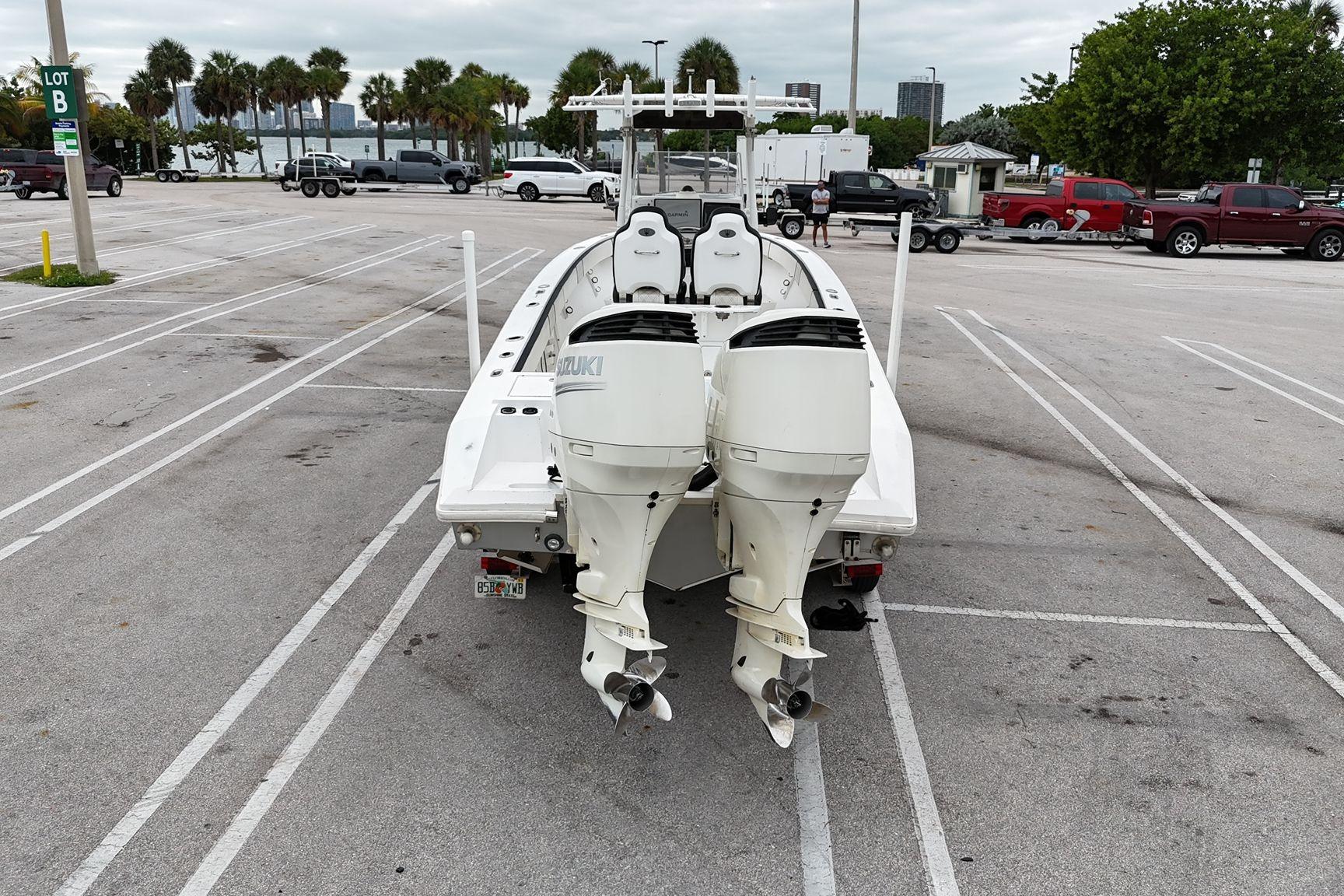 2002 Island Runner 31 boat with dual Suzuki outboard motors in a parking lot.