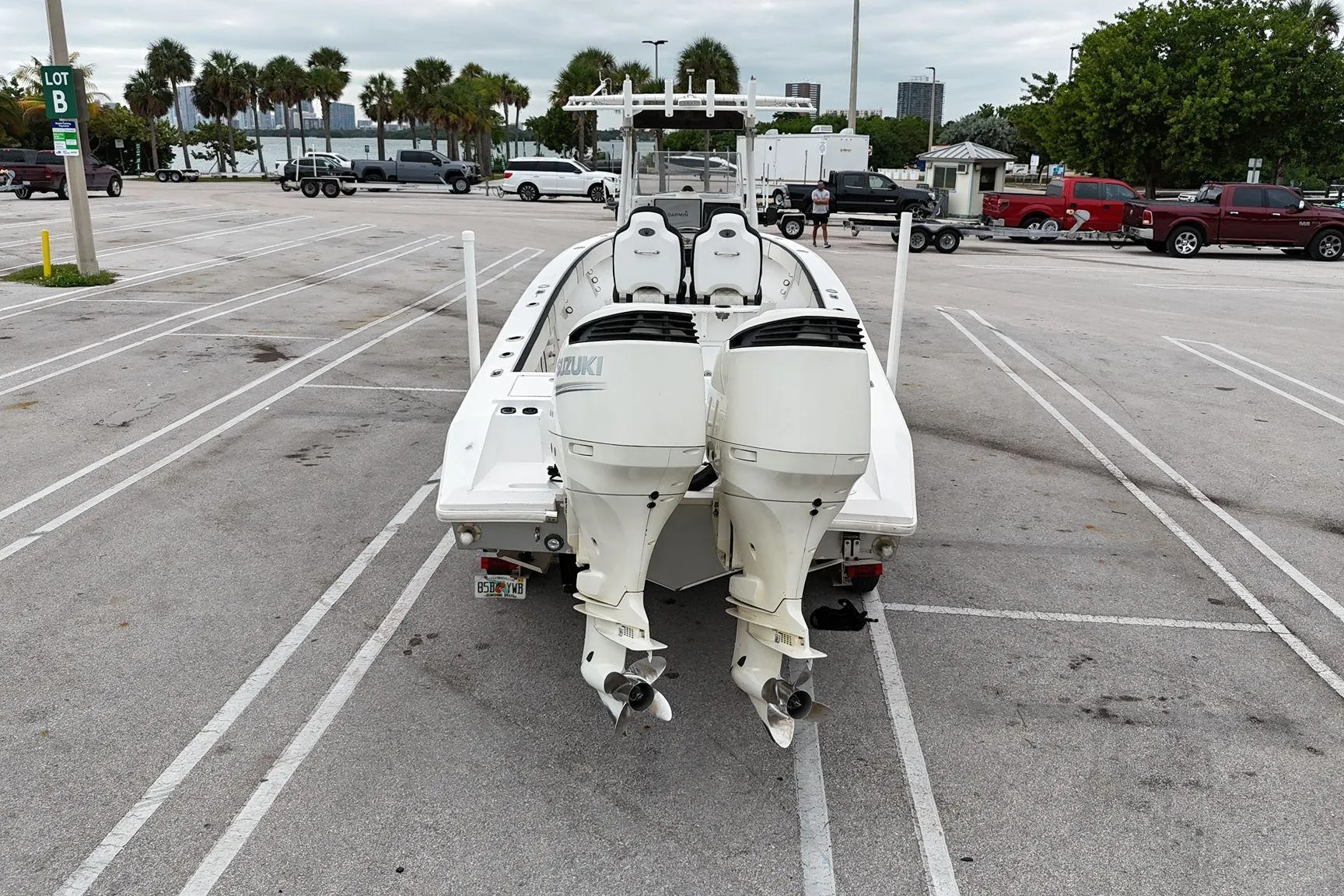 2002 Island Runner 31 boat with dual Suzuki outboard motors in a parking lot.