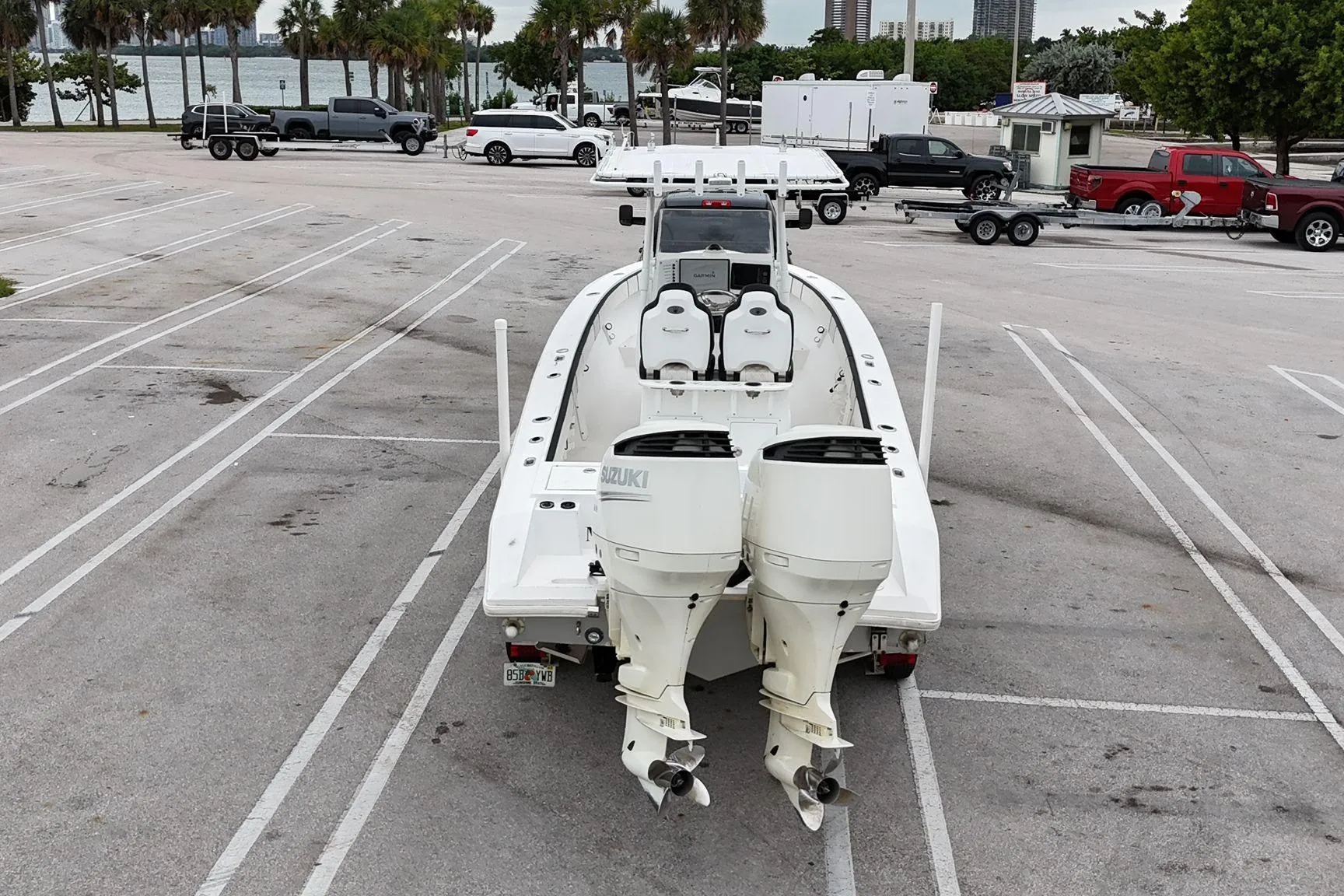 2002 Island Runner 31 boat with dual Suzuki engines in a parking lot near water.