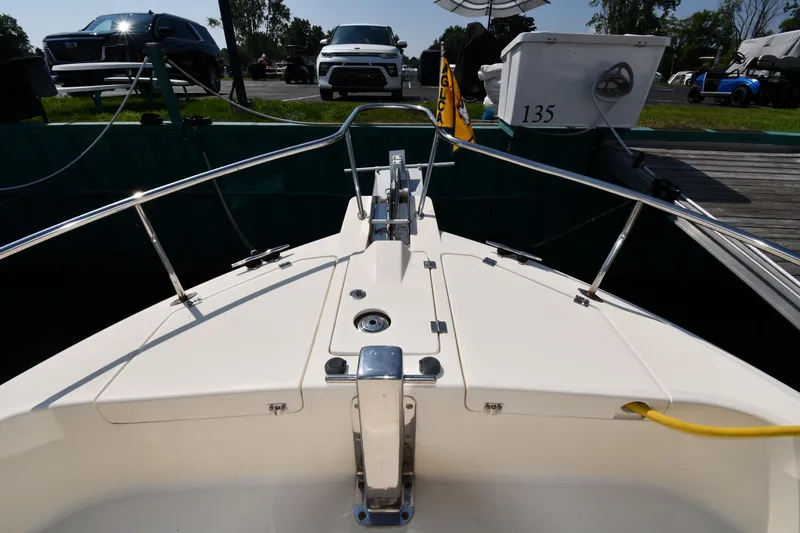 Make Me Smile Yacht Photos Pics 2006 Mainship 40 Trawler bow view at dock with parked vehicles nearby.
