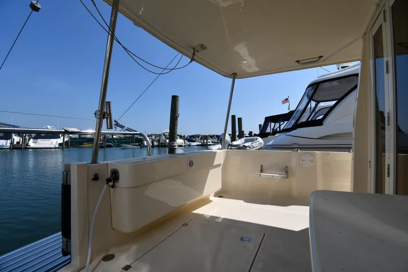 Make Me Smile Yacht Photos Pics 2006 Mainship 40 Trawler docked at marina, featuring spacious deck and clear blue sky.