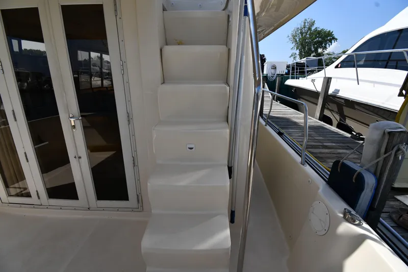 Make Me Smile Yacht Photos Pics Staircase on 2006 Mainship 40 Trawler yacht, leading to upper deck, docked at marina.