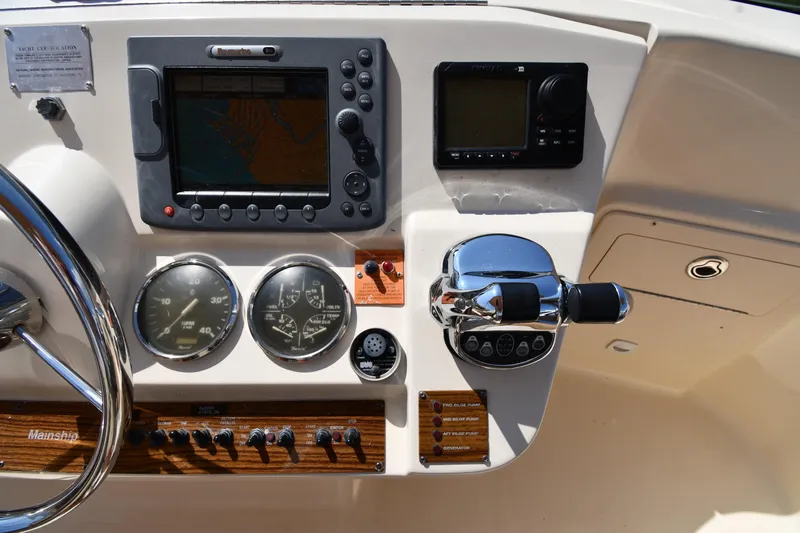 Make Me Smile Yacht Photos Pics Control panel of a 2006 Mainship 40 Trawler with navigation and throttle controls.