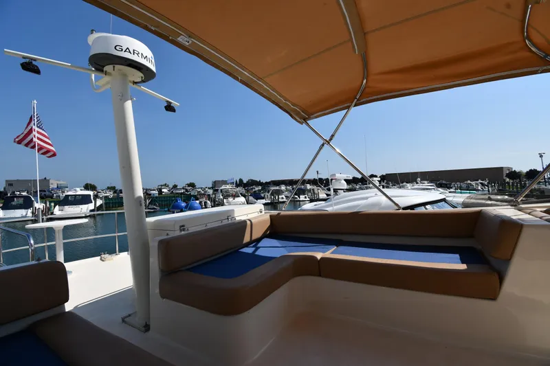 Make Me Smile Yacht Photos Pics 2006 Mainship 40 Trawler with seating, docked at marina under clear blue sky.