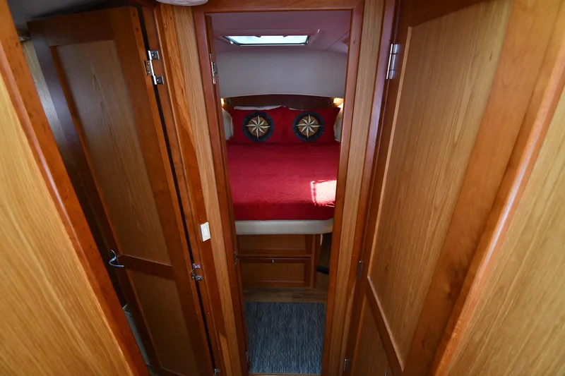 Make Me Smile Yacht Photos Pics 2006 Mainship 40 Trawler cabin interior with wooden doors and red bedding.