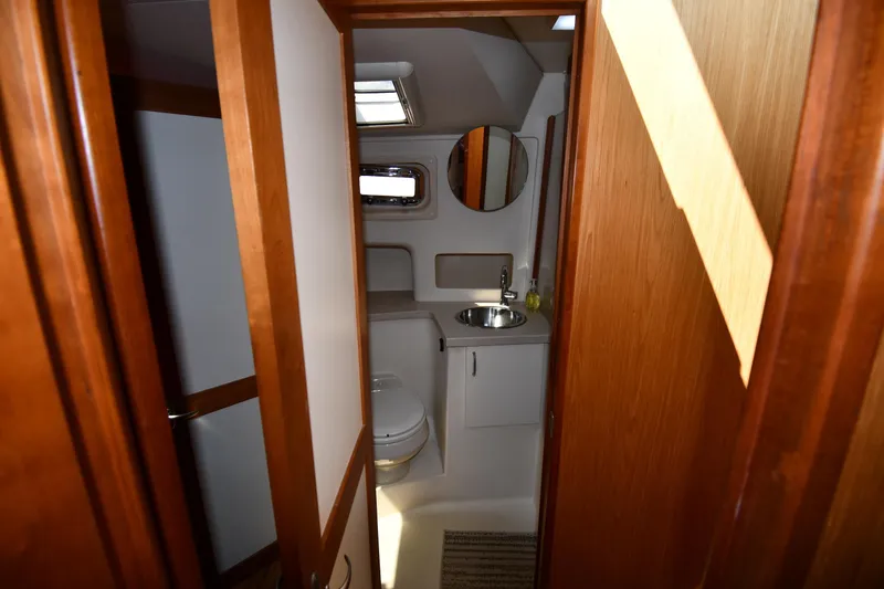 Make Me Smile Yacht Photos Pics Bathroom interior of 2006 Mainship 40 Trawler with wooden accents and modern fixtures.