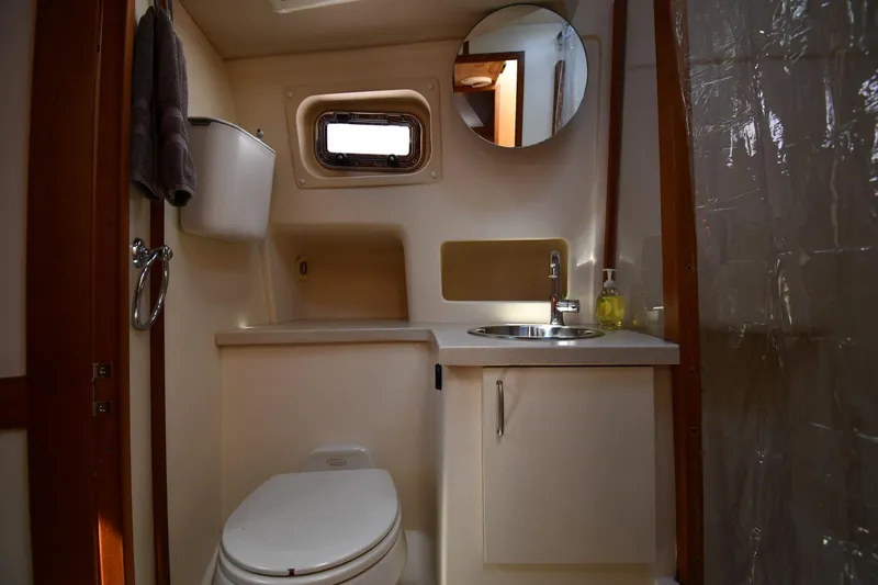 Make Me Smile Yacht Photos Pics 2006 Mainship 40 Trawler bathroom with sink, toilet, and porthole window.