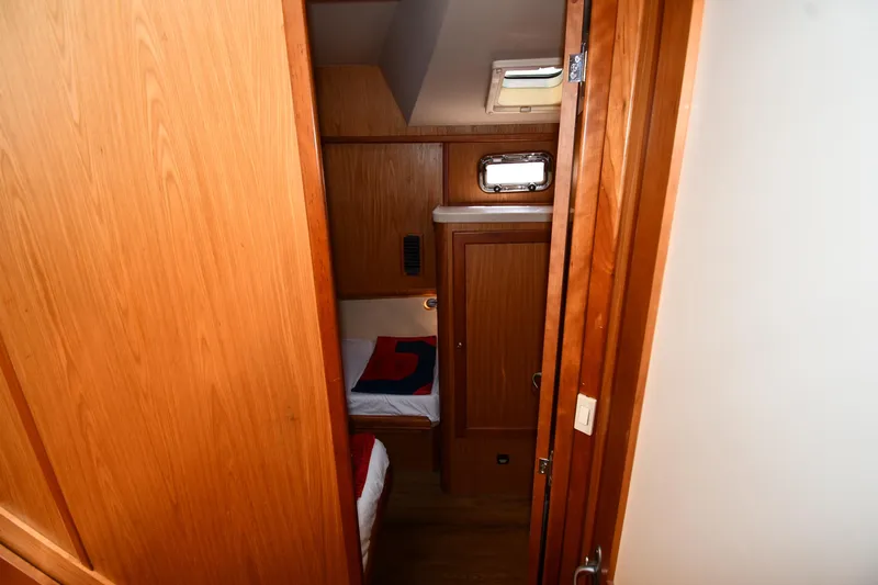 Make Me Smile Yacht Photos Pics Cozy cabin interior of 2006 Mainship 40 Trawler with wooden finishes and bedding.