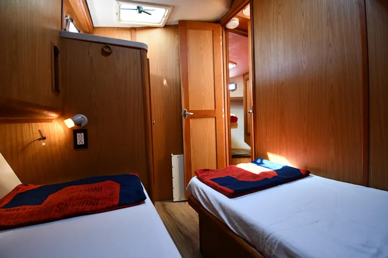 Make Me Smile Yacht Photos Pics Interior of 2006 Mainship 40 Trawler with twin beds and wooden paneling.