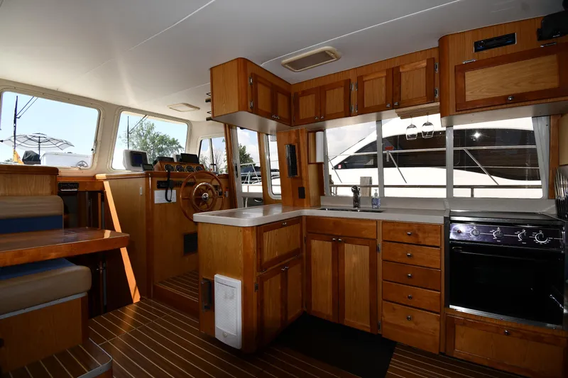 Make Me Smile Yacht Photos Pics Interior of 2006 Mainship 40 Trawler with wooden cabinetry and modern kitchen amenities.